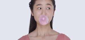 Teenager popping pink chewing gum
