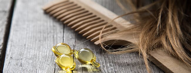 hair care oil, comb and hair in close up