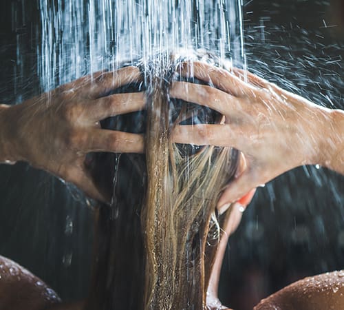 Close up of the back of a woman's head while she is in the shower