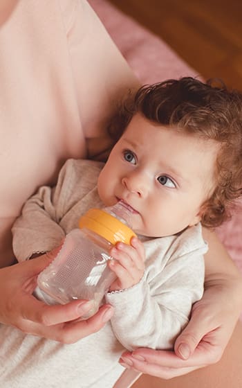 Mother bottle feeding her child