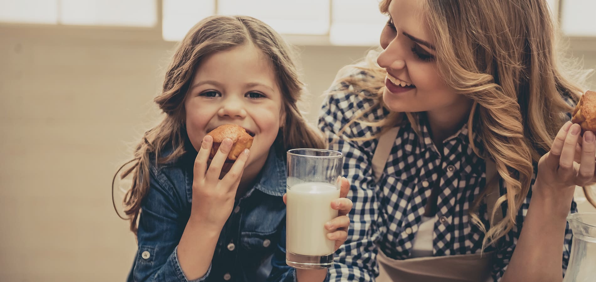 mother and daughter eating cookies and drinking milk
